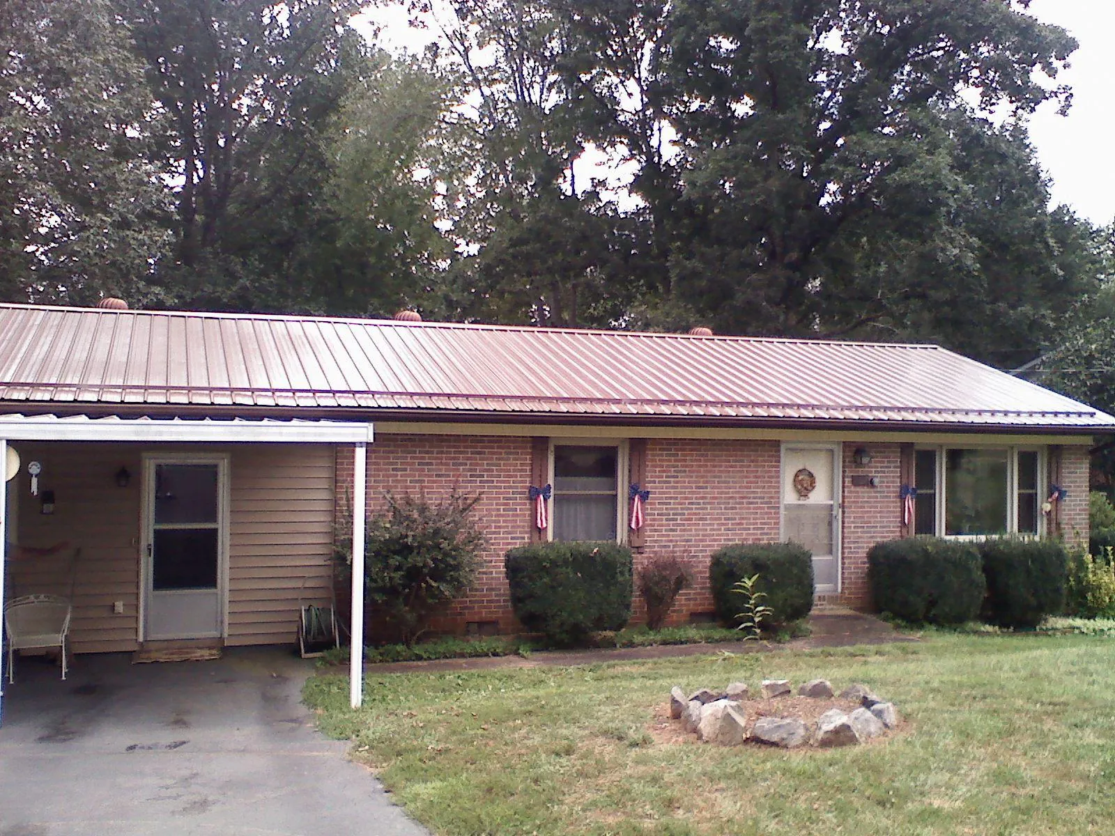 Bronze metal roof and carport on a brick ranch home in Salina